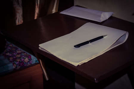 A pen and paper on the deskの写真素材