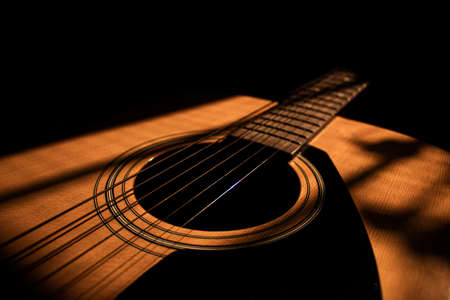 Sun rays fall on an acoustic guitarの写真素材