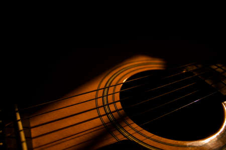 Sun rays fall on an acoustic guitarの写真素材
