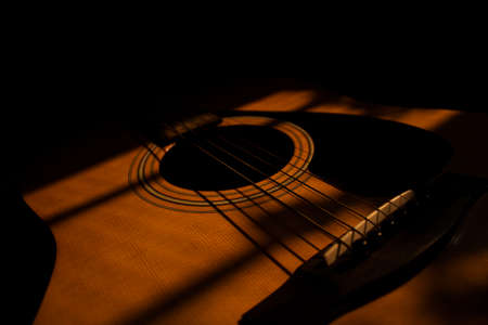 Sun rays fall on an acoustic guitarの写真素材