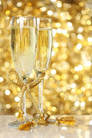 Champagne flutes with golden backgroundの写真素材
