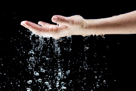 Water falling on handの写真素材