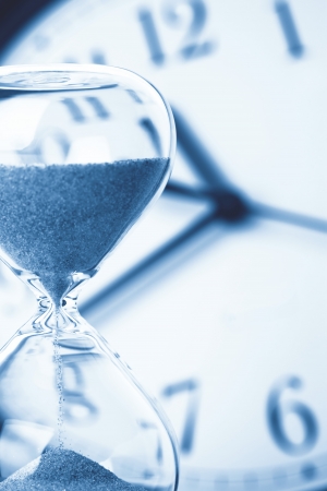 Concept of time - Hourglass and clockの写真素材