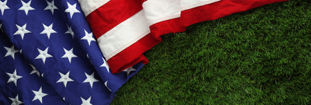 Red, white, and blue American flag on grass for Memorial Day or Veteran's day backgroundの写真素材