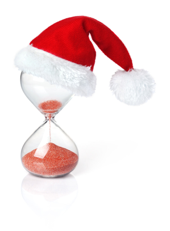 Hourglass with Christmas Santa hat showing the passage of timeの写真素材