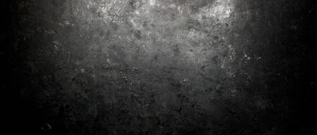 Rough, dark stone background lit by spotlight backgroundの写真素材