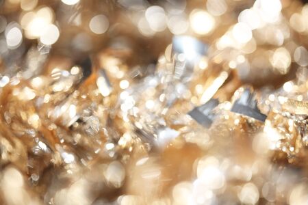 Abstract bokeh of sparkling gold and silver Christmas tinsel backgroundの写真素材