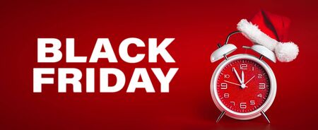 Red clock with Christmas Santa hat and Black Friday text. Time for Christmas shopping concept.の写真素材
