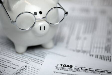 US Tax forms with piggybankの写真素材