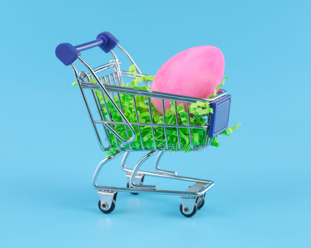 Pink Easter egg in shopping cart for Easter shopping concept.