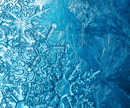 Wintry background with winter frost covered window with a pattern of ice crystals and clear...