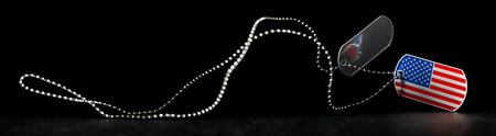 Falling US military soldier's dog tags with chain with one in the shape of the American flag. Memorial Day for Veterans Day concept.の写真素材
