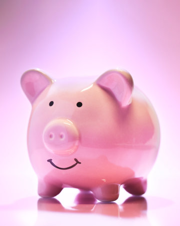 Smiling Piggybank on pink background. Saving money concept.の写真素材