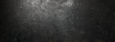 Rough, dark stone background lit by spotlight backgroundの写真素材