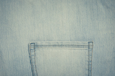 Worn and weathered blue jeans denim material with simple empty pocket.の写真素材