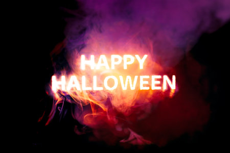 Glowing Happy Halloween text burning red, orange, and purple smokeの写真素材
