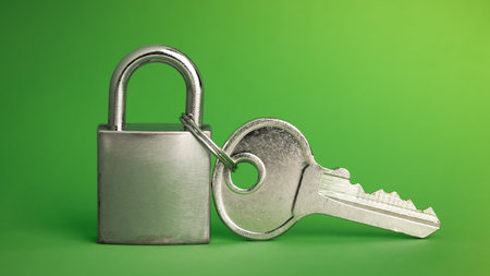 Simple lock and key. Small worn padlock with over large shiny key. Business data encryption, home security, or other safeguarding metaphor.の写真素材