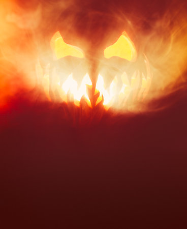 Scary Halloween jack o lantern face glowing in smoke and fire.の写真素材