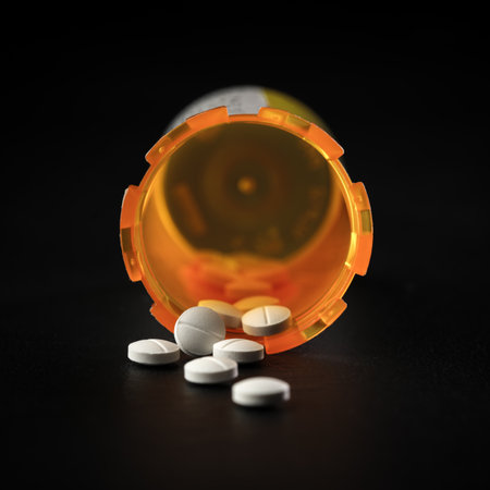 Close up of a prescription pill bottle with white pill tablets. Concept for addiction, accidental poisoning, or overdose and suicide.の写真素材