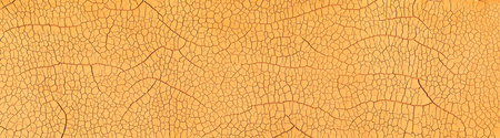 Detailed cracked soil showing a dry desert land scorched in the heat causing cracks. Global warming or Climate change concept.の写真素材