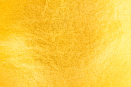 Shiny gold background made of rough textured gold leaf.の写真素材