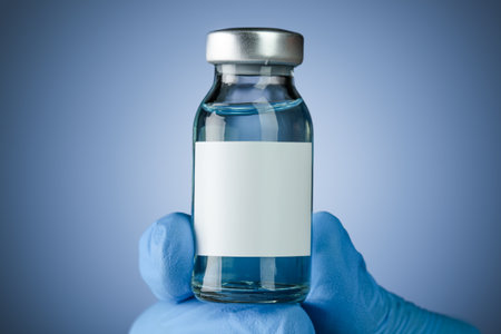 Hand in blue medical gloves holding a vaccine vial with blank white space for text. Healthcare concept with copyspace for text.の写真素材