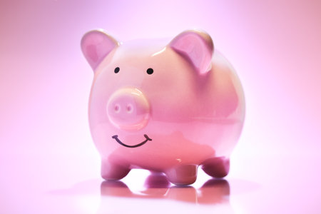 Smiling Piggybank on pink background. Saving money concept.の写真素材