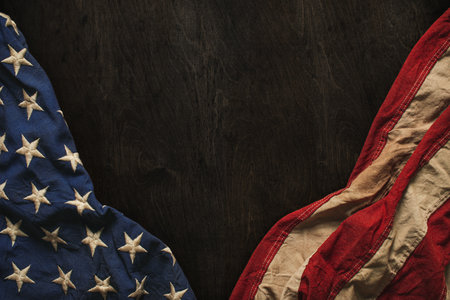 Vintage US American flag crumpled on worn wooden background. Blank copy space for text. For USA Memorial day, Veterans day, 4th of July, or other patriotic holiday.の写真素材