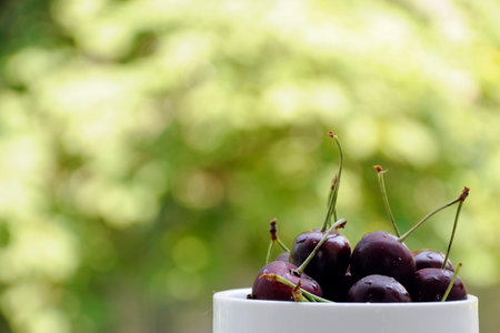 Fresh cherries in bowl on tableの写真素材