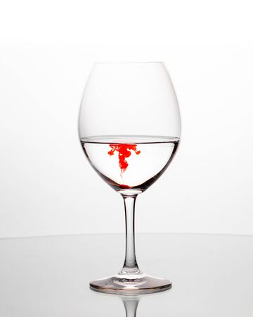 Elegant wineglasses on white background with reflection and vivid colored liquidの写真素材