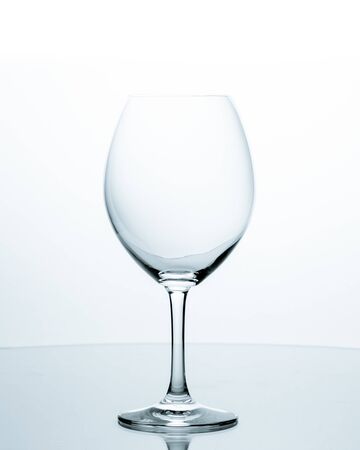 Elegant empty wineglasses on white background with reflectionの写真素材