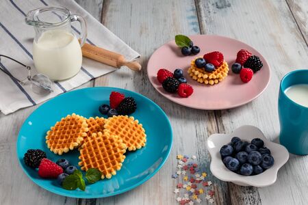 Traditional Belgian waffles with fresh fruit and milk. Rustic kitchen table.の写真素材