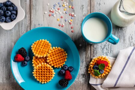 Traditional Belgian waffles with fresh fruit and milk. Flat lay, top viewの写真素材