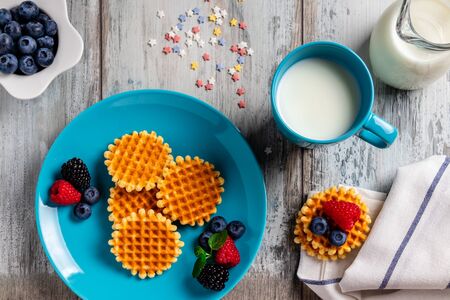 Traditional Belgian waffles with fresh fruit and milk. Flat lay, top viewの写真素材