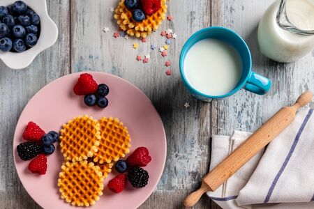 Traditional Belgian waffles with fresh fruit and milk. Flat lay, top viewの写真素材