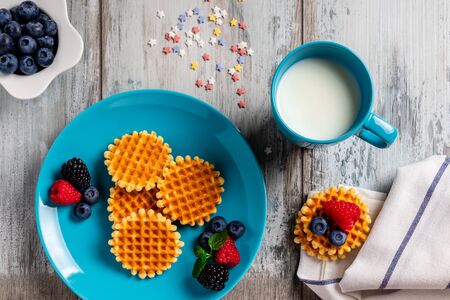 Traditional Belgian waffles with fresh fruit and milk. Flat lay, top viewの写真素材