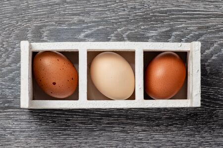 Fresh farmer market brown and white eggs on a kitchen table with utensilsの写真素材