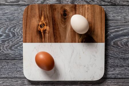 Fresh farmer market eggs on a kitchen table with utensilsの写真素材