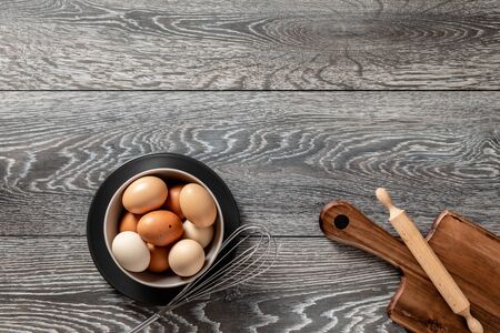 Fresh farmer market eggs on a kitchen table with utensilsの写真素材