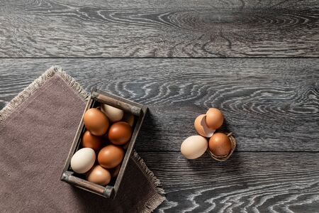 Fresh farmer market brown and white eggs on a kitchen table with utensilsの写真素材