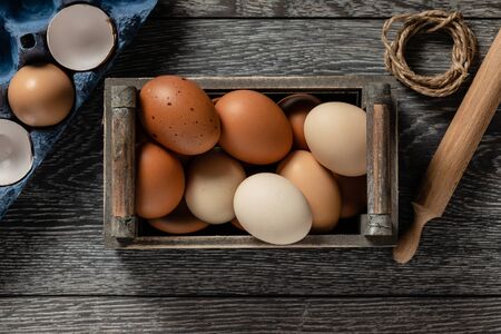 Fresh farmer market eggs on a kitchen table with utensilsの写真素材
