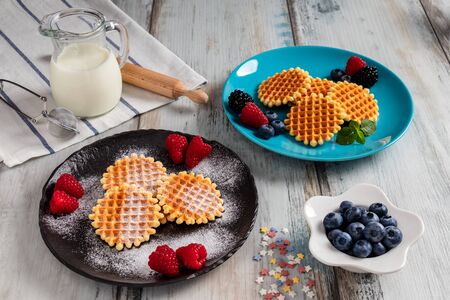 Traditional Belgian waffles with fresh fruit and milk. Rustic kitchen table.の写真素材