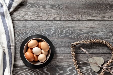 Fresh farmer market brown and white eggs on a kitchen table with utensilsの写真素材