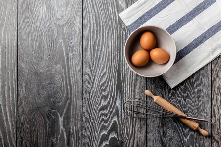 Fresh farmer market brown and white eggs on a kitchen table with utensilsの写真素材