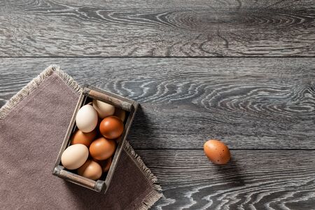 Fresh farmer market brown and white eggs on a kitchen table with utensilsの写真素材