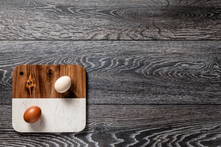 Fresh farmer market eggs on a kitchen table with utensilsの写真素材