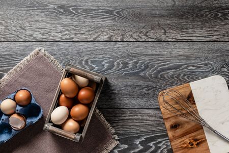 Fresh farmer market eggs on a kitchen table with utensilsの写真素材