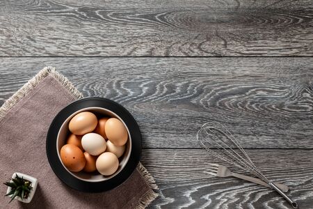 Fresh farmer market eggs on a kitchen table with utensilsの写真素材