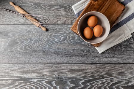 Fresh farmer market eggs on a kitchen table with utensilsの写真素材