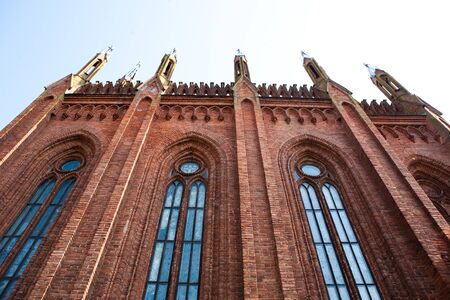 The wall of the church of red brick with a spireの写真素材